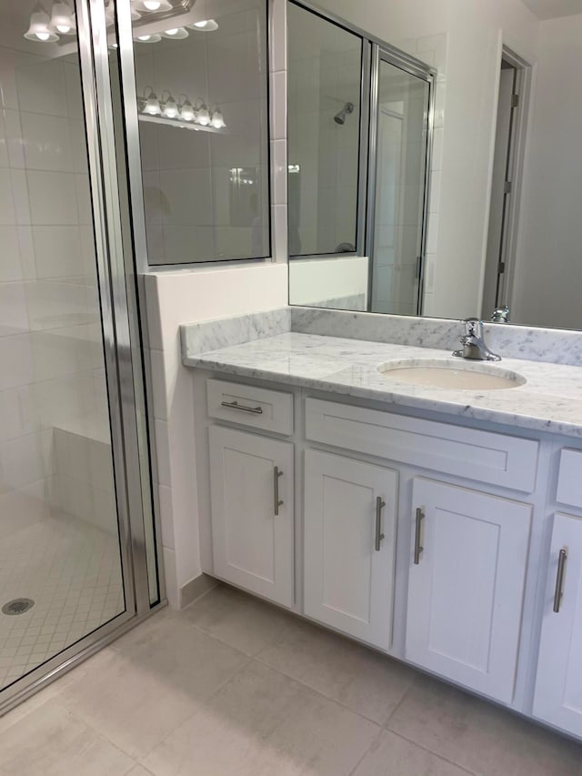 bathroom featuring vanity, tile patterned floors, and a shower with door