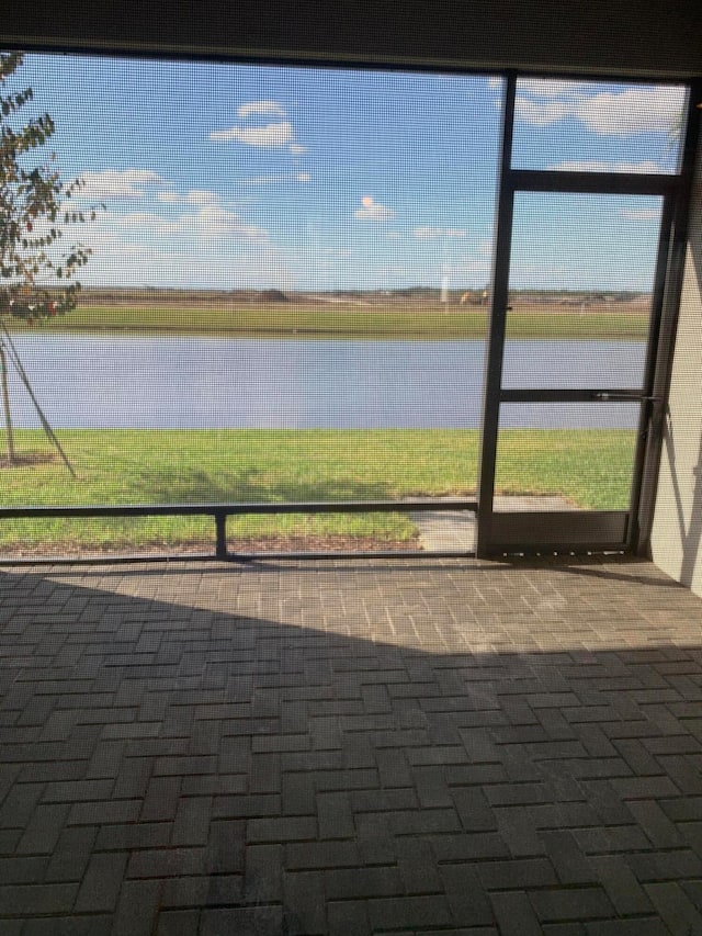 unfurnished sunroom featuring a water view