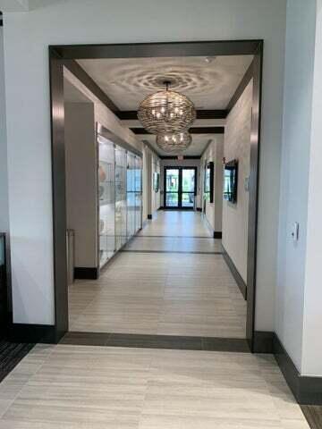 hallway featuring french doors, light hardwood / wood-style floors, and a notable chandelier