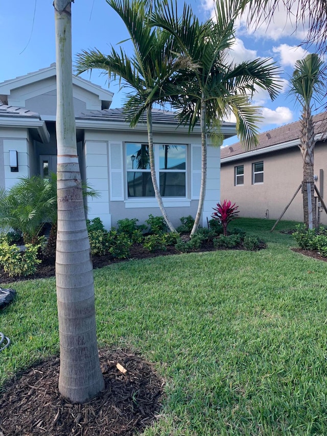 view of side of home with a yard