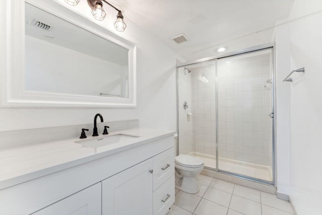 bathroom with tile patterned floors, toilet, an enclosed shower, and vanity