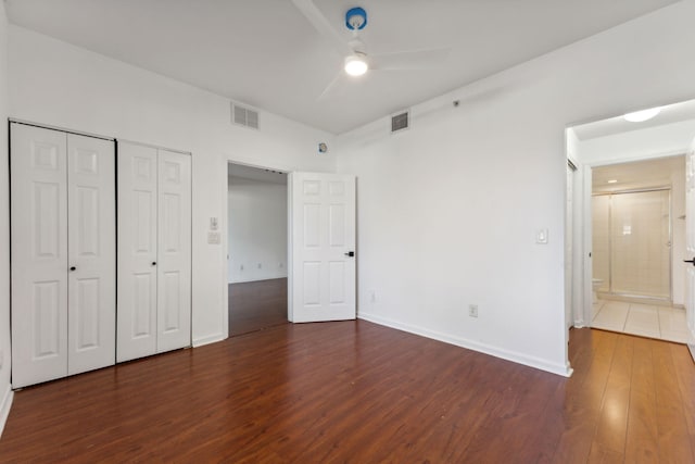 unfurnished bedroom featuring dark hardwood / wood-style floors, ceiling fan, and a closet