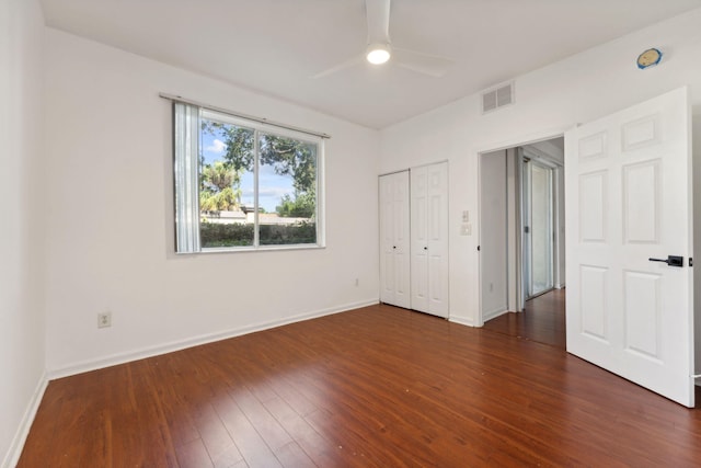 unfurnished bedroom featuring dark wood-type flooring, ceiling fan, and a closet