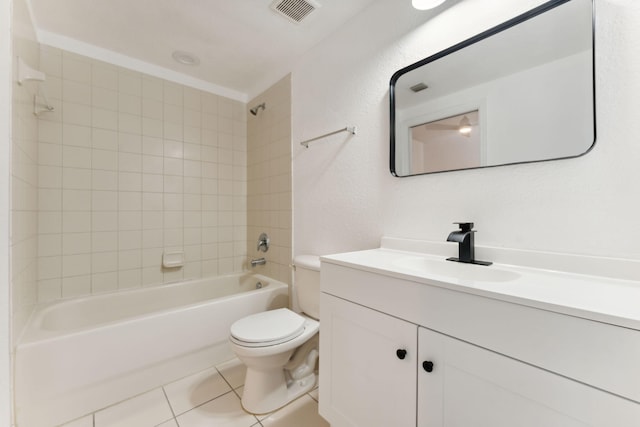 full bathroom featuring tile patterned flooring, vanity, tiled shower / bath combo, and toilet