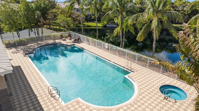 view of pool with a hot tub and a water view