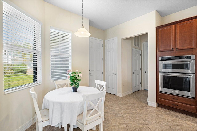 tiled dining room with a textured ceiling