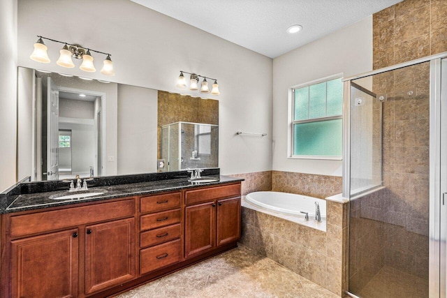 bathroom with vanity, a textured ceiling, and shower with separate bathtub