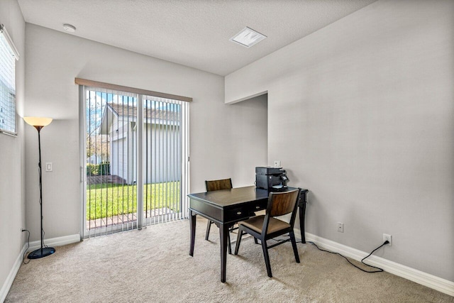 carpeted home office with a wealth of natural light and a textured ceiling