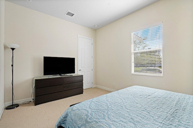 bedroom with light carpet, visible vents, and baseboards