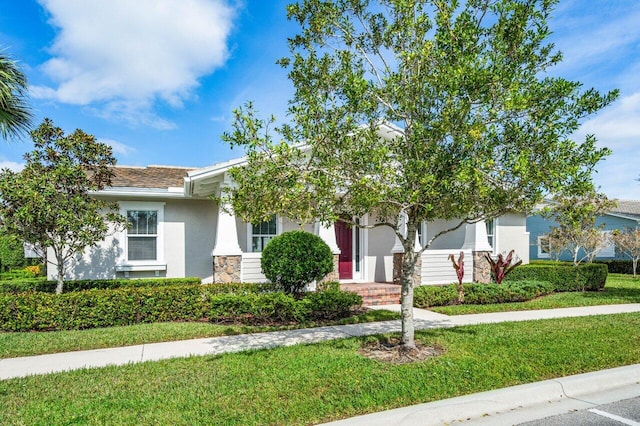 view of property hidden behind natural elements featuring a front lawn