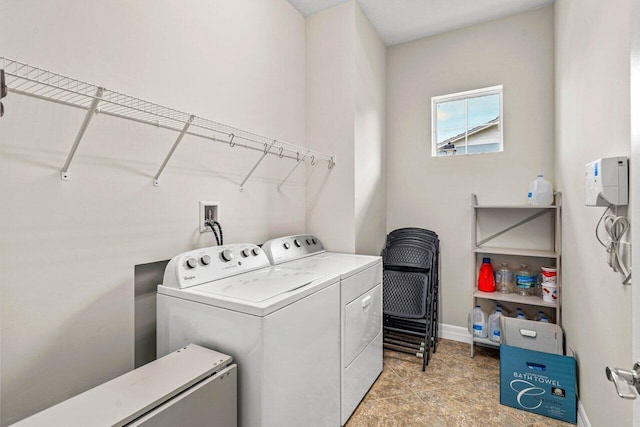 washroom with washing machine and dryer, laundry area, and baseboards