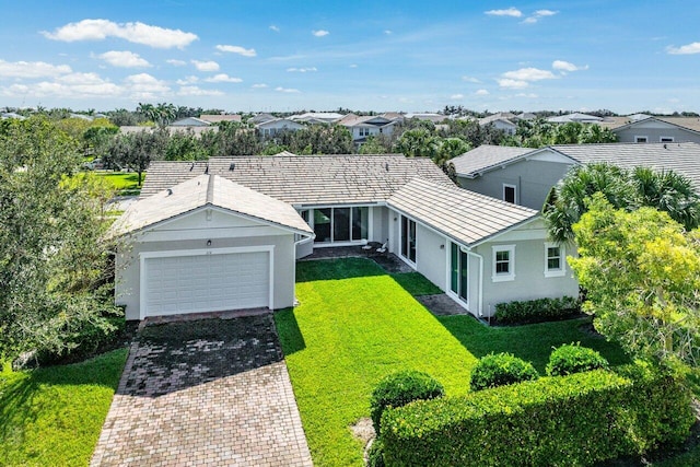 view of front of house with a residential view, a front lawn, decorative driveway, and stucco siding