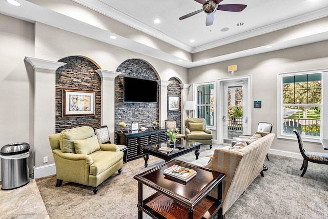 living room with ceiling fan, ornamental molding, and a raised ceiling