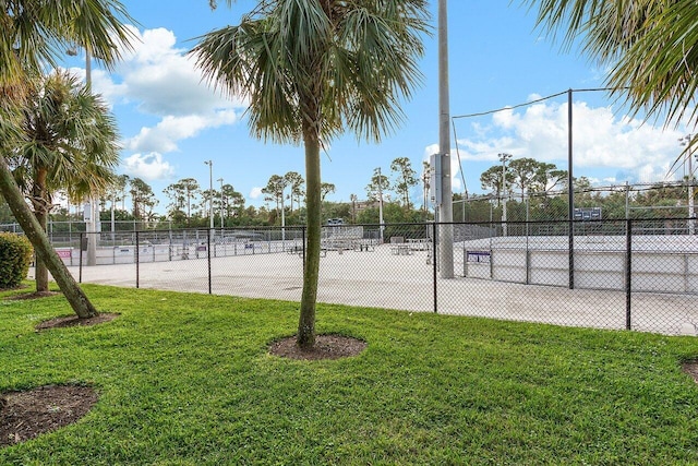 view of tennis court featuring a lawn