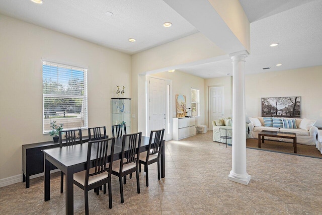 dining room with a textured ceiling and ornate columns