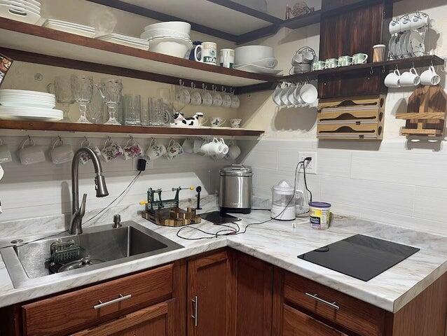 bar featuring decorative backsplash, black electric cooktop, and sink