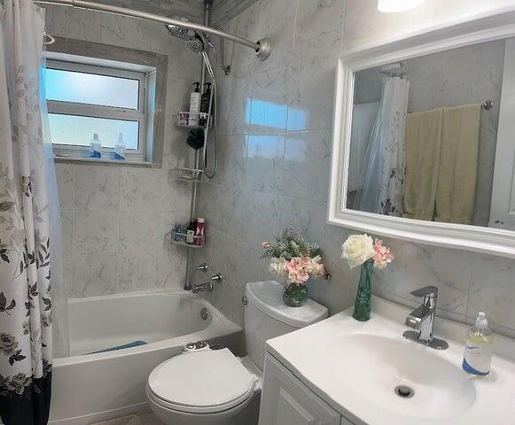 full bathroom with vanity, toilet, and shower / tub combo with curtain