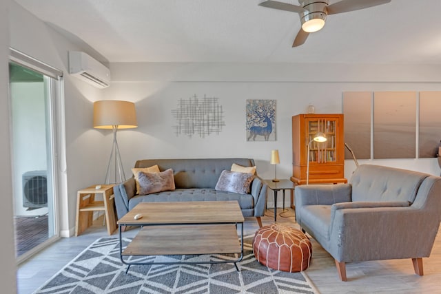 living room featuring hardwood / wood-style floors, ceiling fan, and a wall unit AC