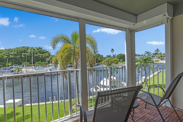 sunroom / solarium featuring a water view