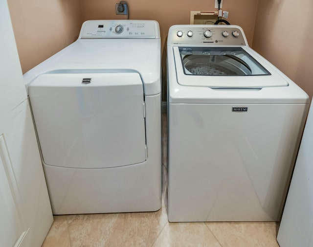 laundry area with light tile patterned flooring and washing machine and clothes dryer