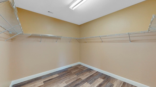 spacious closet with hardwood / wood-style flooring