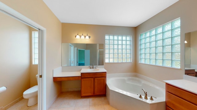 bathroom featuring tile patterned flooring, vanity, toilet, and a tub