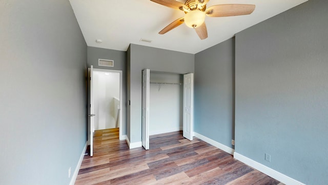 unfurnished bedroom featuring hardwood / wood-style floors, a closet, and ceiling fan