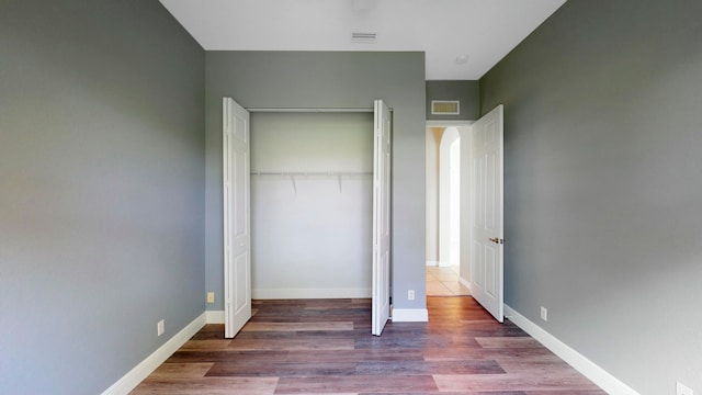 unfurnished bedroom featuring dark hardwood / wood-style floors and a closet