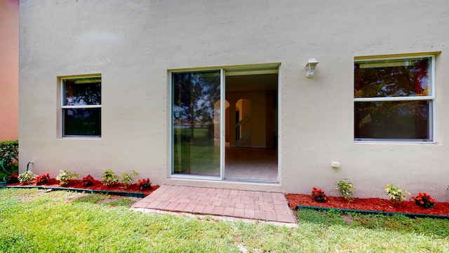 view of exterior entry with a yard