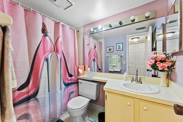 bathroom featuring tile patterned flooring, vanity, and toilet