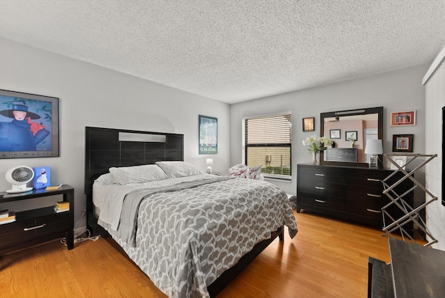 bedroom with light hardwood / wood-style floors and a textured ceiling