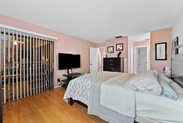 bedroom featuring hardwood / wood-style floors and a textured ceiling