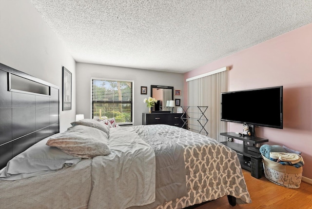 bedroom featuring hardwood / wood-style floors and a textured ceiling