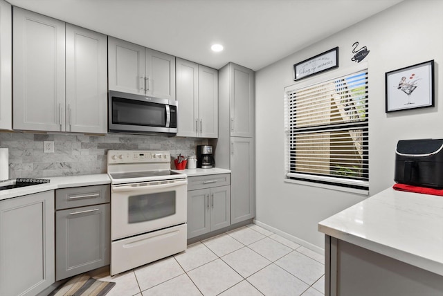 kitchen featuring electric range, tasteful backsplash, gray cabinetry, and light tile patterned flooring