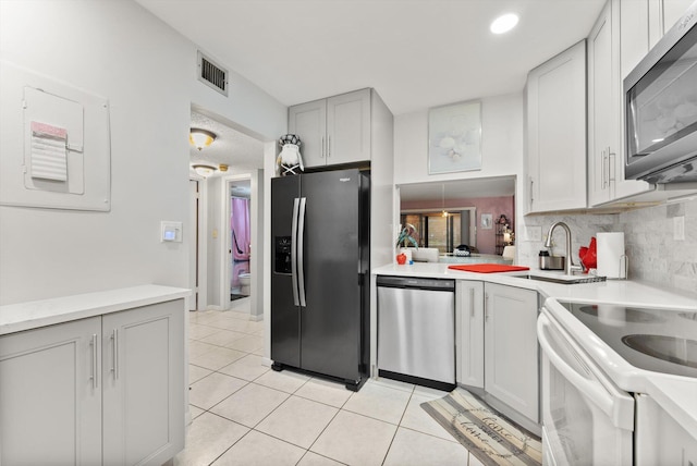 kitchen featuring decorative backsplash, light tile patterned floors, and stainless steel appliances