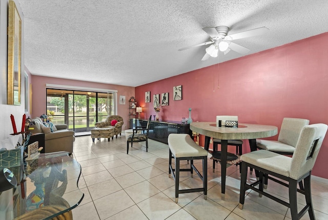 tiled dining area featuring ceiling fan and a textured ceiling