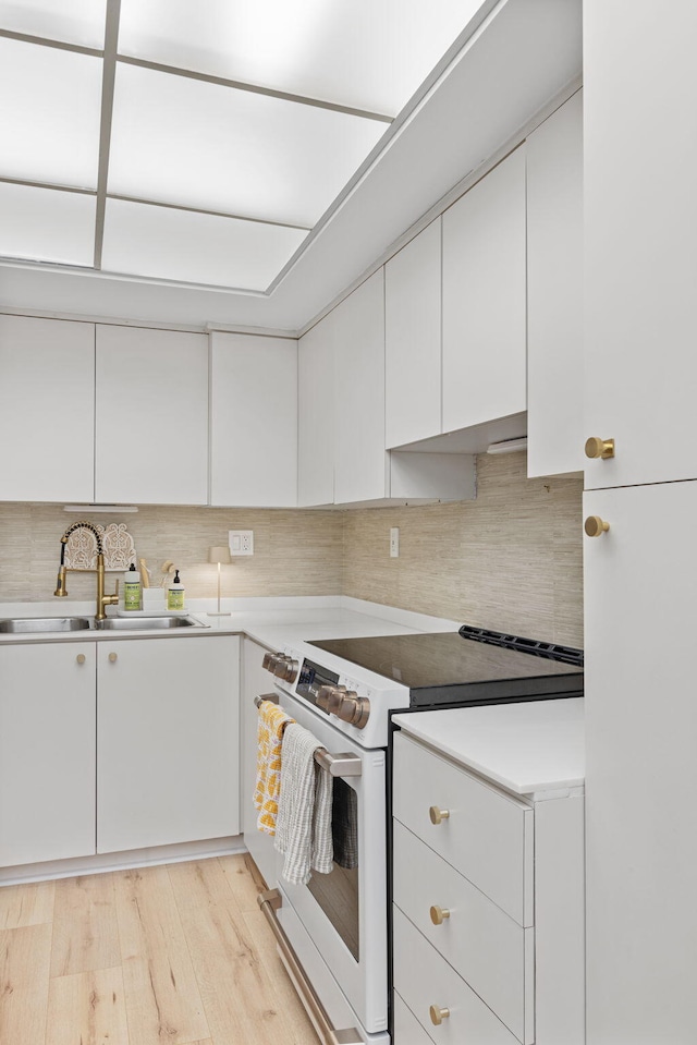 kitchen with backsplash, sink, white cabinets, white electric range, and light hardwood / wood-style floors