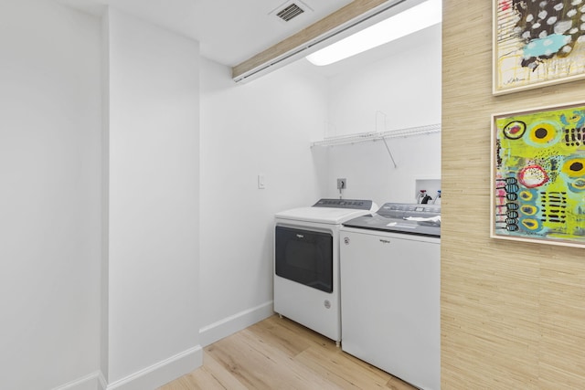 washroom featuring washer and clothes dryer and light wood-type flooring