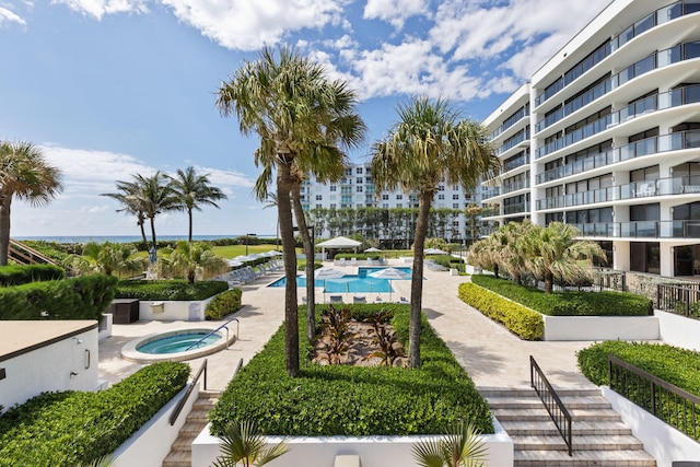 view of home's community featuring a patio and a pool with hot tub