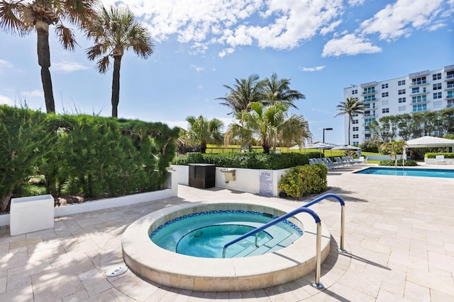 view of swimming pool featuring a community hot tub and a patio area