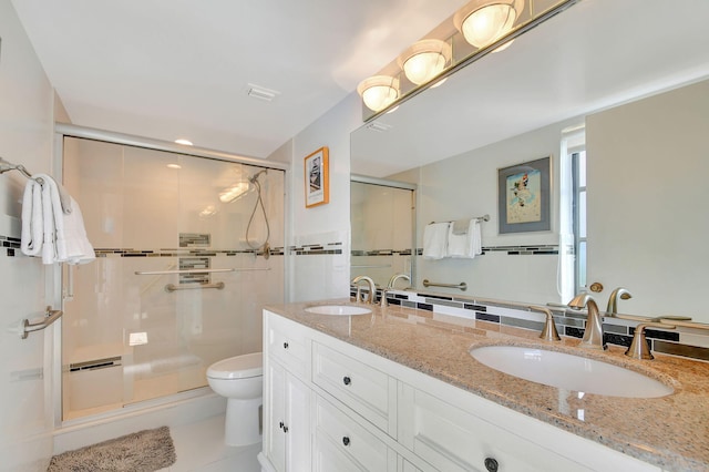 bathroom featuring tile patterned floors, a shower with door, vanity, and toilet