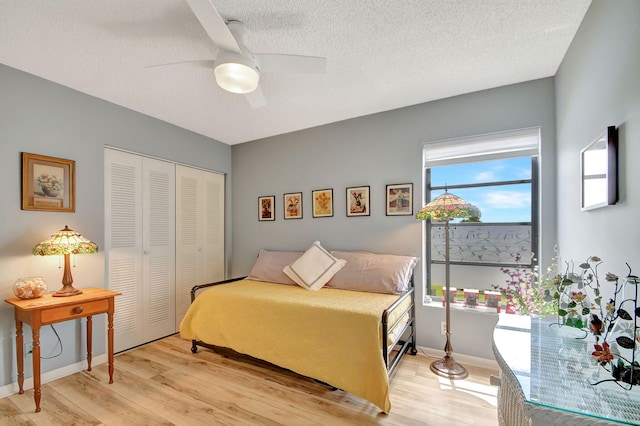 bedroom with ceiling fan, a closet, a textured ceiling, and light hardwood / wood-style flooring