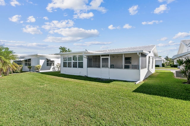 rear view of house with a lawn and a sunroom