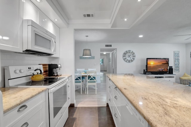 kitchen with backsplash, light stone counters, white appliances, decorative light fixtures, and white cabinetry