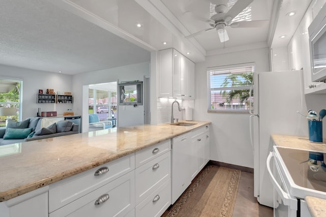 kitchen featuring white cabinets, white appliances, plenty of natural light, and light stone countertops