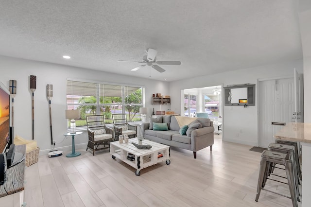 living room featuring a textured ceiling, light hardwood / wood-style floors, and a healthy amount of sunlight