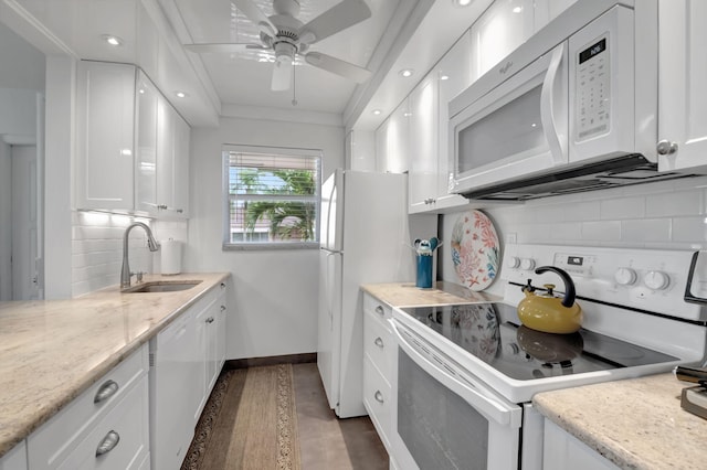 kitchen with white appliances, backsplash, dark wood-type flooring, white cabinets, and sink