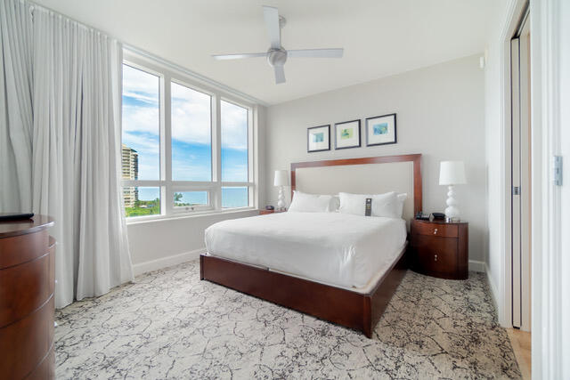 bedroom featuring a water view and ceiling fan