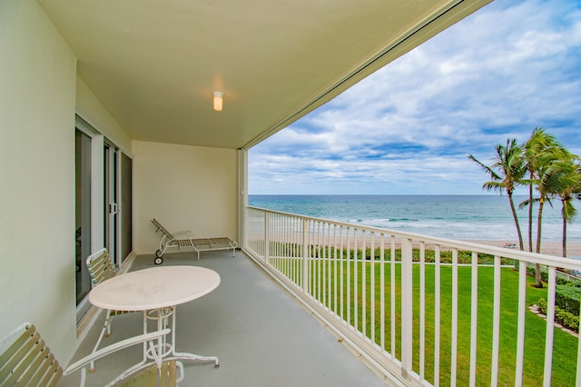 balcony featuring a water view, radiator, and a view of the beach