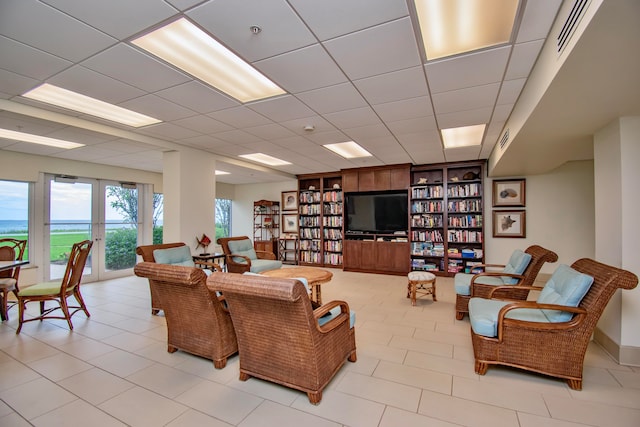 tiled living room featuring a drop ceiling